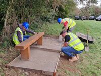 Volunteers from Tanium laying a base to a bench September