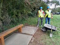 Tanium volunteers adding a concrete base to the bench